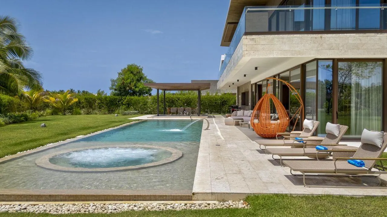 A round spa set into the terrace, loungers along the pool