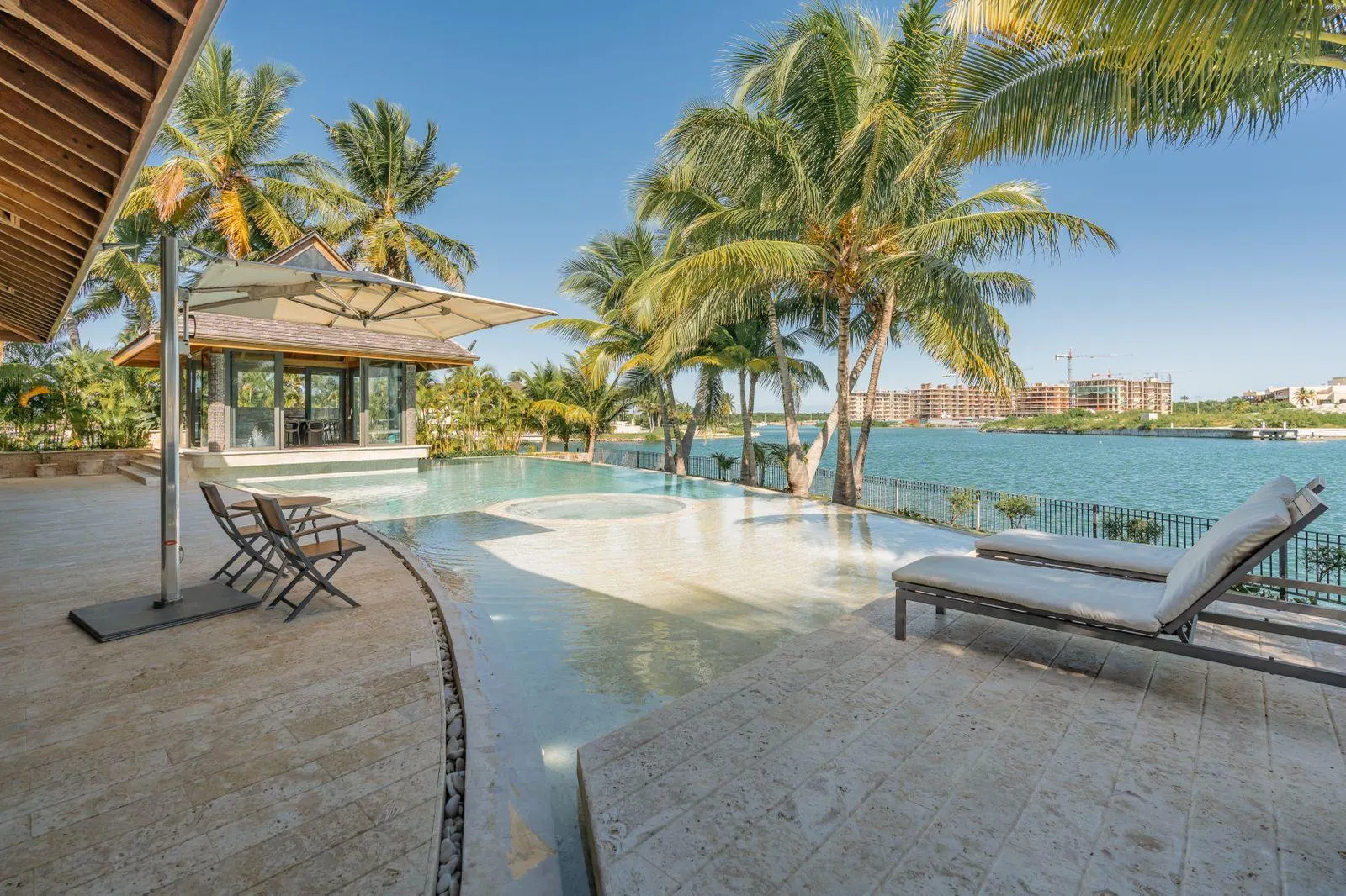 Loungers by the pool, the canal and the palms beyond
