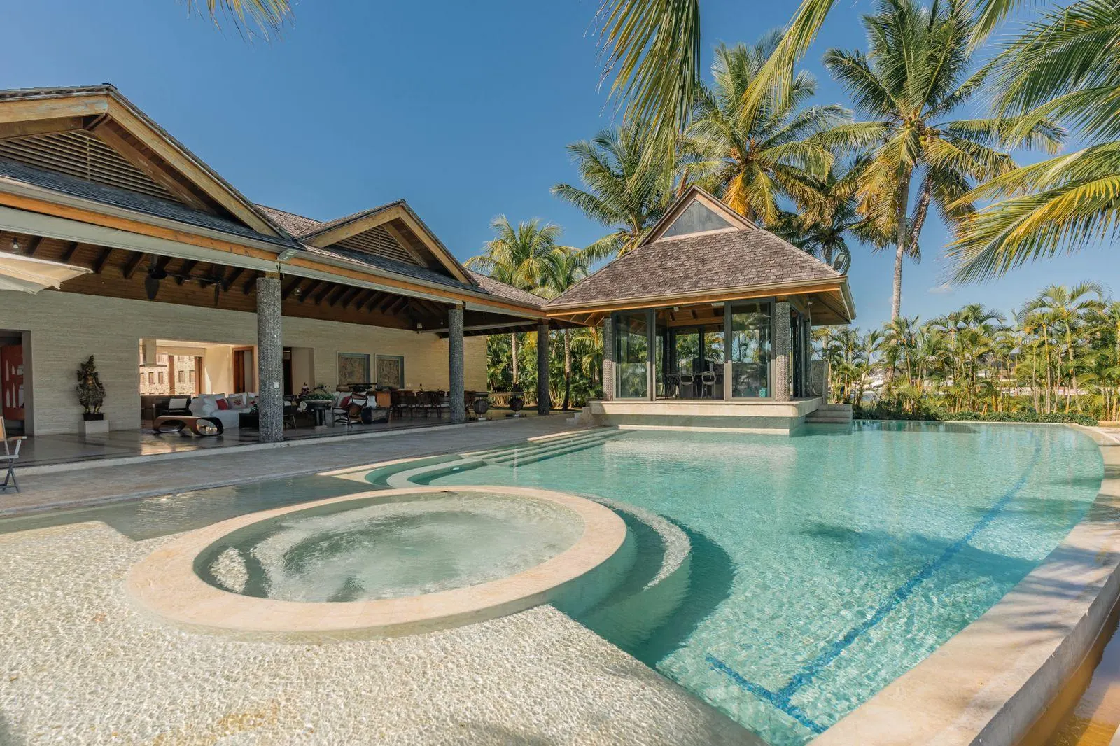 The house under its roofs, a round spa set into the pool