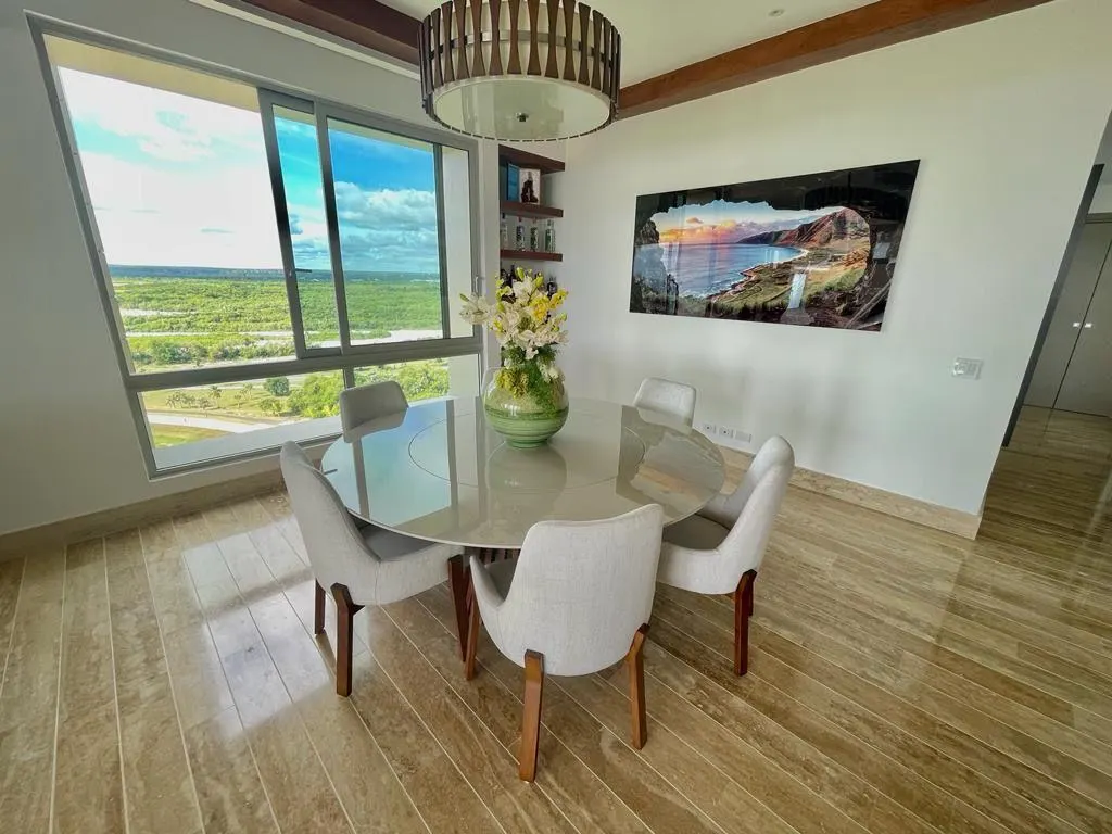 A dining table under a pendant light, the view through the window