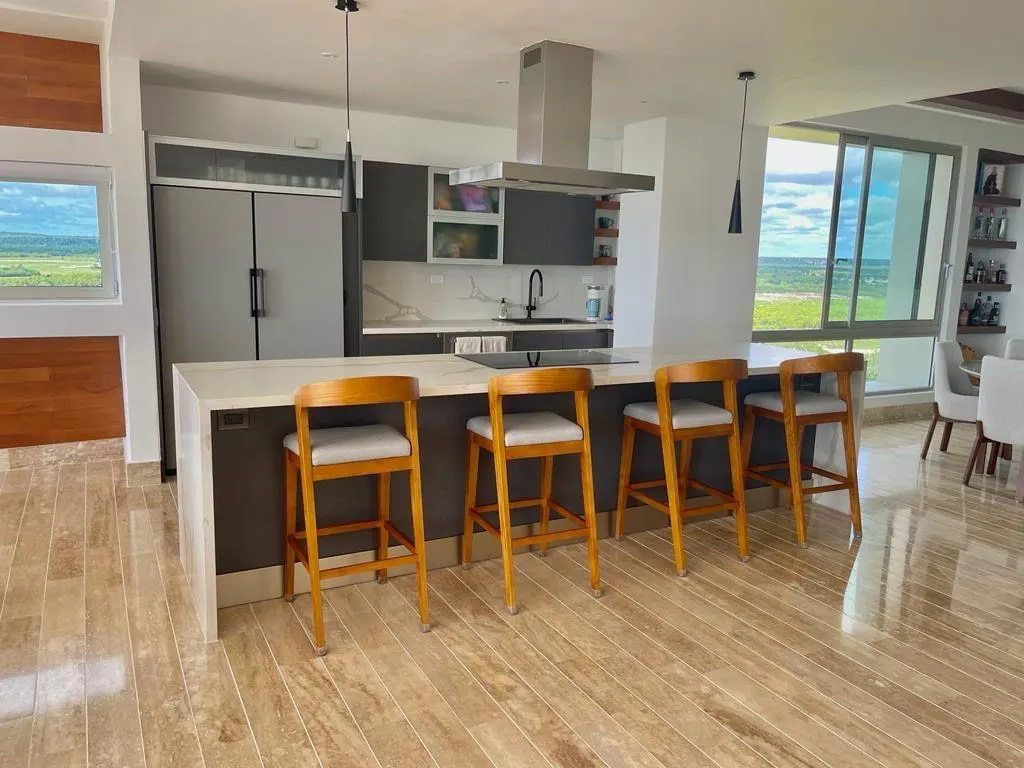 An open kitchen with a long island and tall stools