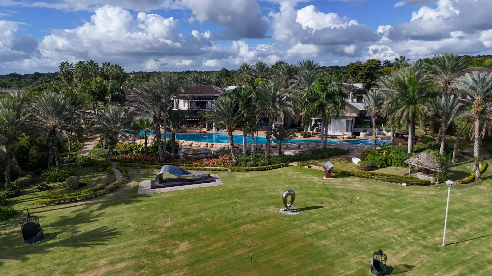 The lawn and the gardens before the house, palms all around
