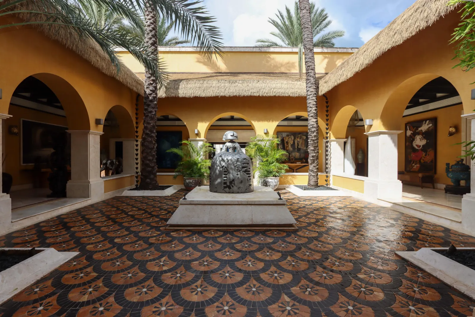 A courtyard of arches around a patterned stone floor