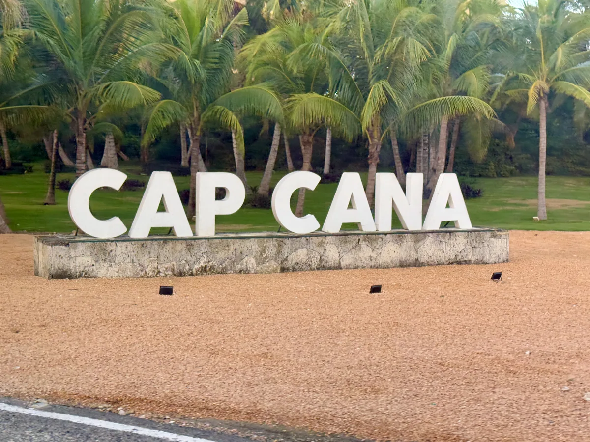 The entrance of Cap Cana: the name in white letters on a stone base, under the palms