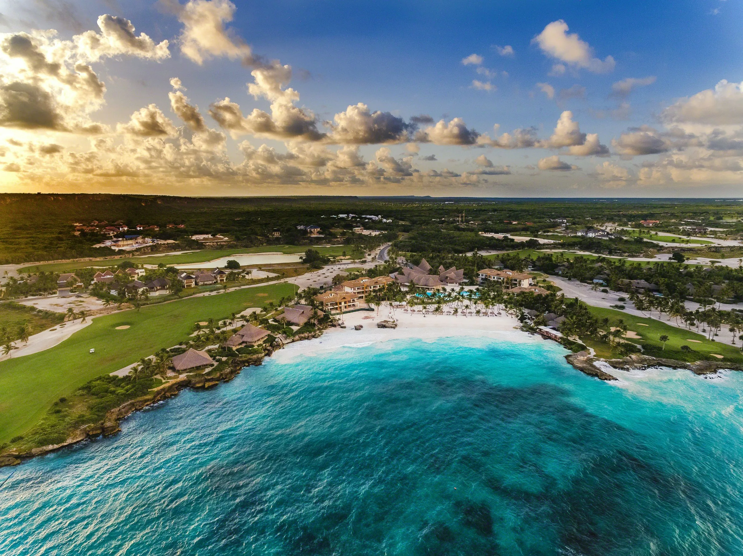 Cap Cana from the air: the bay, the beach, the golf course and the estate running inland to the trees