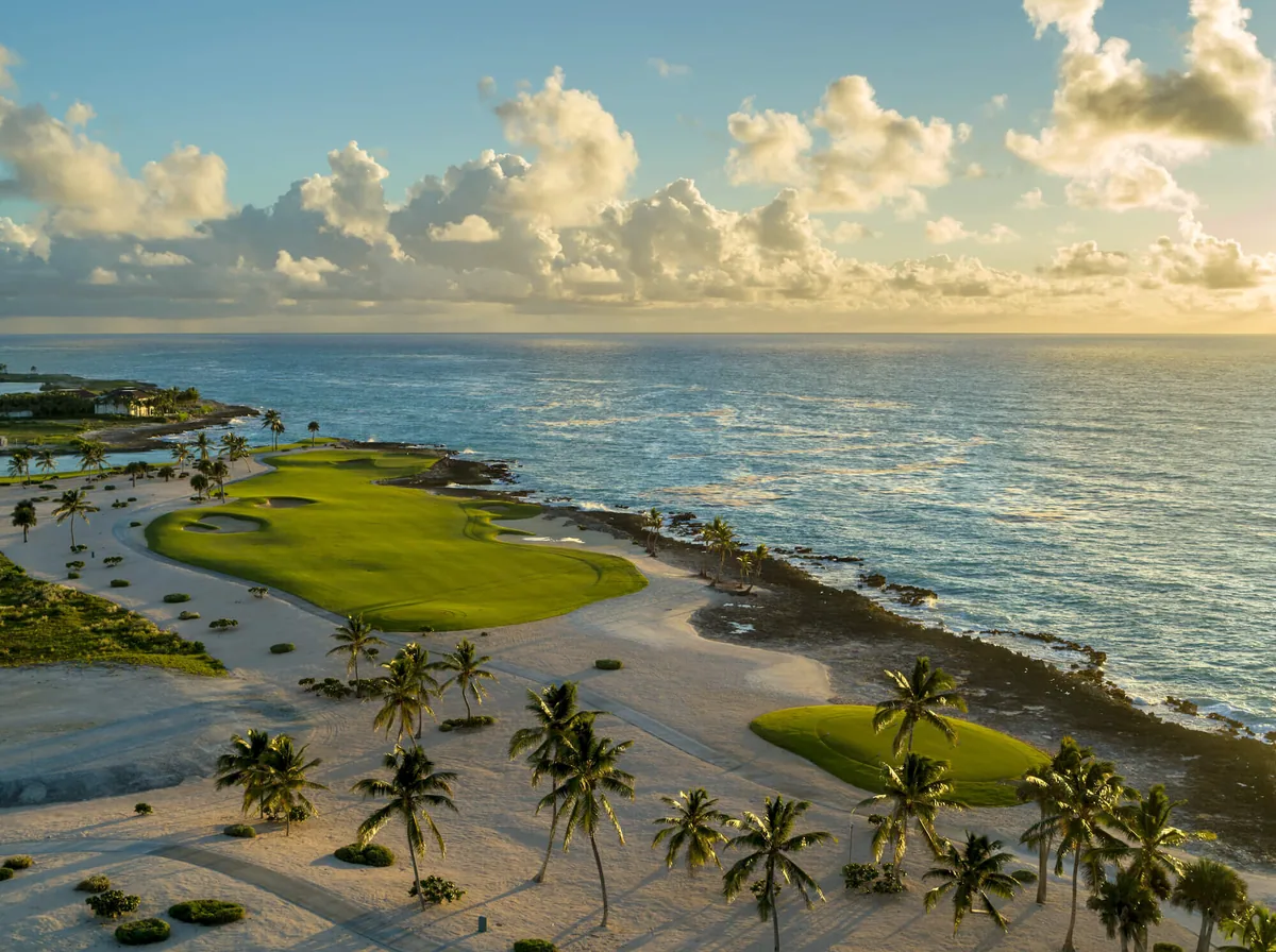 A fairway along the coast, palms and the sea beyond